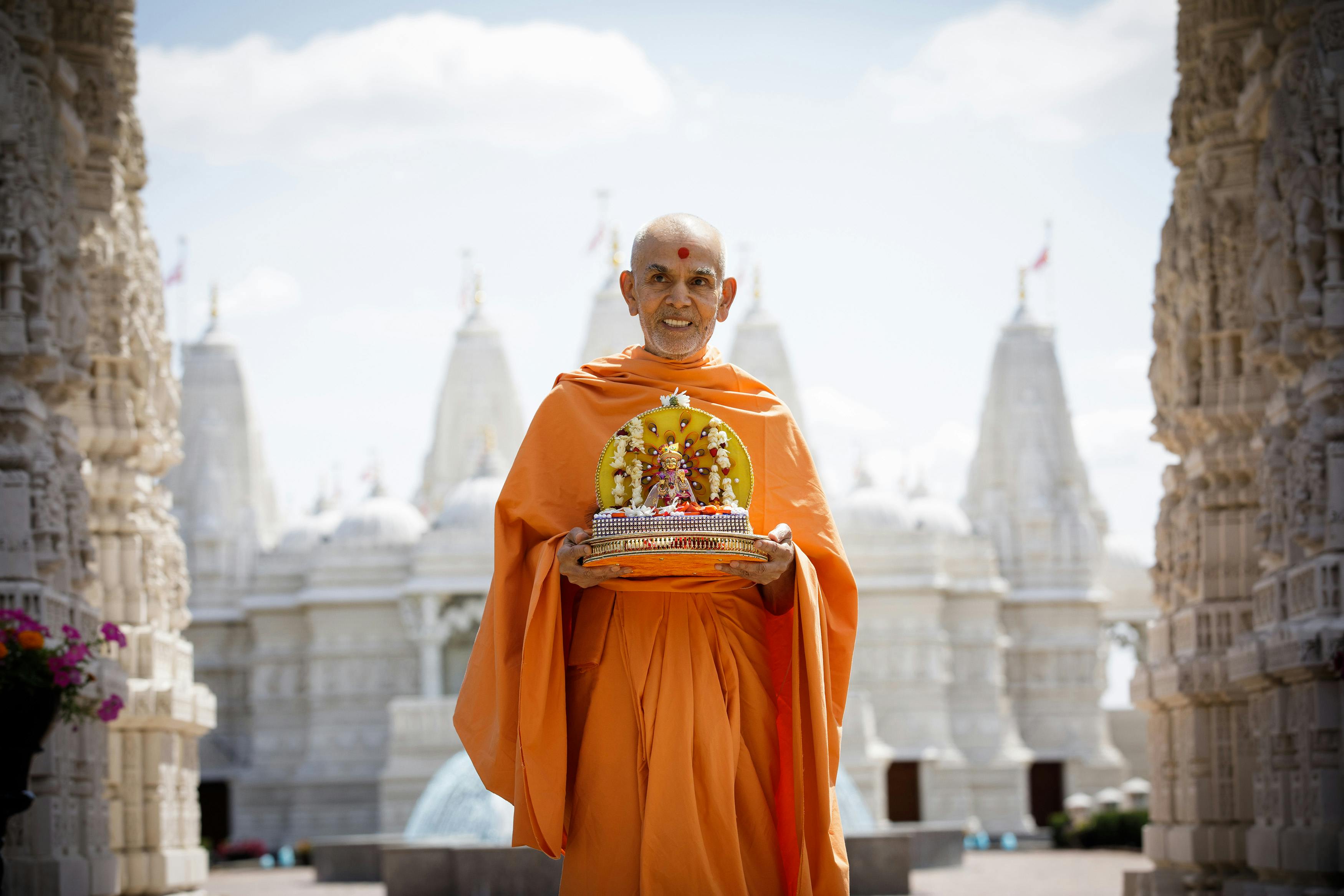 His Holiness Mahant Swami Maharaj standing with Thakorji in front of the BAPS Shri Swaminarayan Mandir in Chicago, Illinois.
