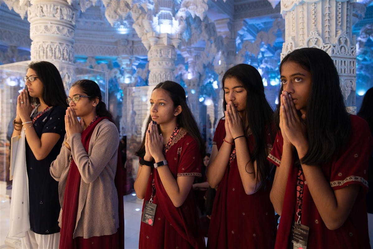 Youths engrossed in darshan of the murtis.